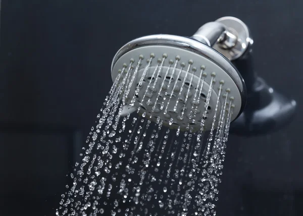 Douchekop in badkamer met waterdruppels stromend — Stockfoto