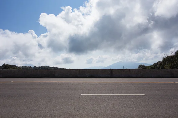 Camino de asfalto con fondo cielo azul nube — Foto de Stock