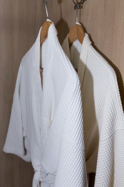 ahşap dolabında asılı beyaz bornoz