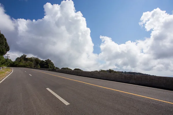 Asfalt karayolu ile bulut mavi gökyüzü arka plan — Stok fotoğraf