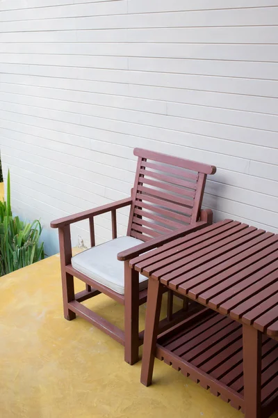 Chaise en bois sur plancher de ciment jaune avec fond de mur de mortier — Photo