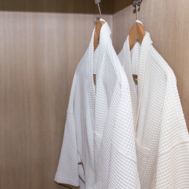 ahşap dolabında asılı beyaz bornoz