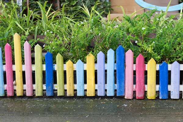 Clôture en bois coloré dans petit jardin — Photo