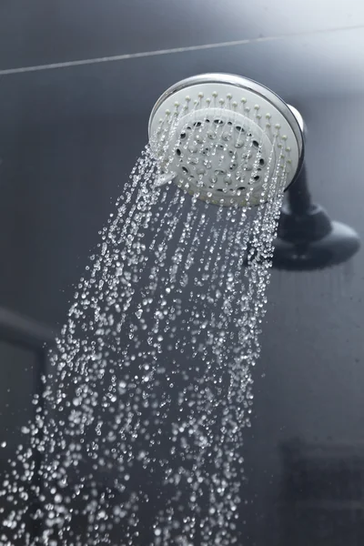 Douchekop in badkamer met waterdruppels stromend — Stockfoto