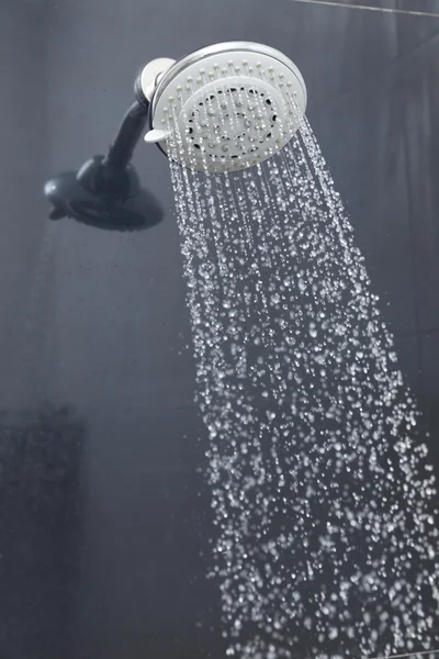 Duschkopf im Bad mit fließenden Wassertropfen — Stockfoto