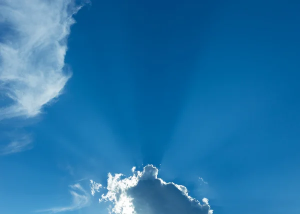 Rays of sunbeam on blue sky with clouds — Stock Photo, Image