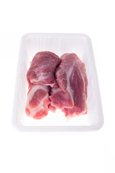 Ruwe varkensvlees in plastic doos pakket geïsoleerd op witte achtergrond — Stockfoto