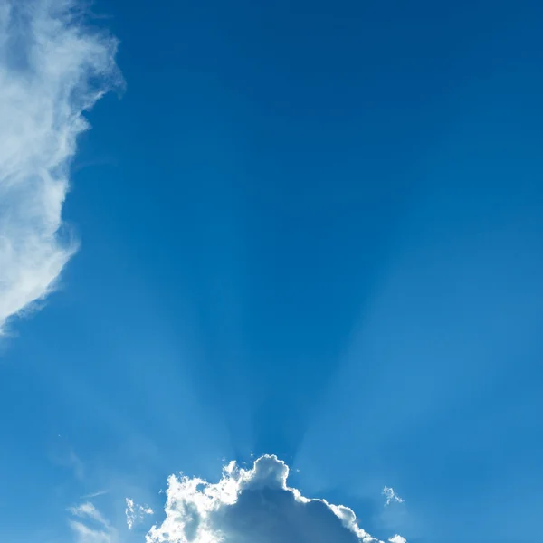 Stralen van sunbeam op blauwe hemel met wolken — Stockfoto