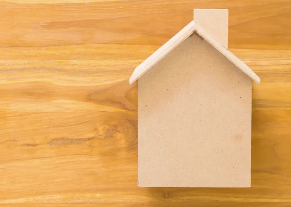 Mały dom z drewna modelu na brązowym tle drewniane — Zdjęcie stockowe