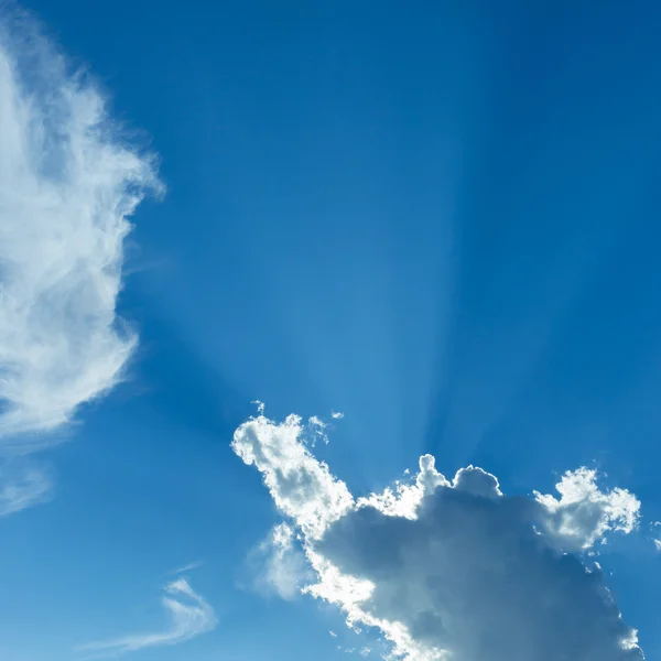 Stralen van sunbeam op blauwe hemel met wolken — Stockfoto