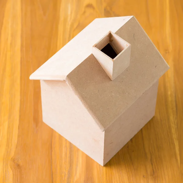 Mały dom z drewna modelu na brązowym tle drewniane — Zdjęcie stockowe