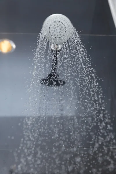 Cabeça de chuveiro no banheiro com gotas de água fluindo — Fotografia de Stock