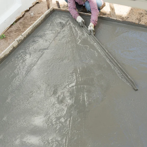 Plasterer concrete cement worker plastering flooring of house co — Stock Photo, Image