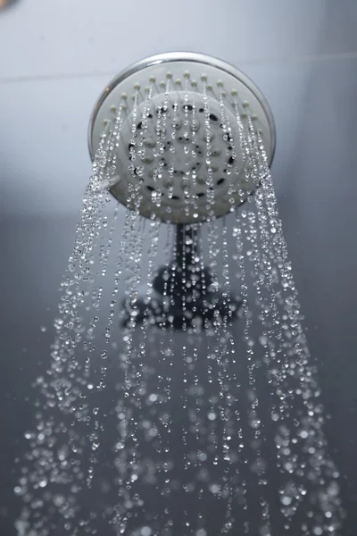 Cabeça de chuveiro no banheiro com gotas de água fluindo — Fotografia de Stock