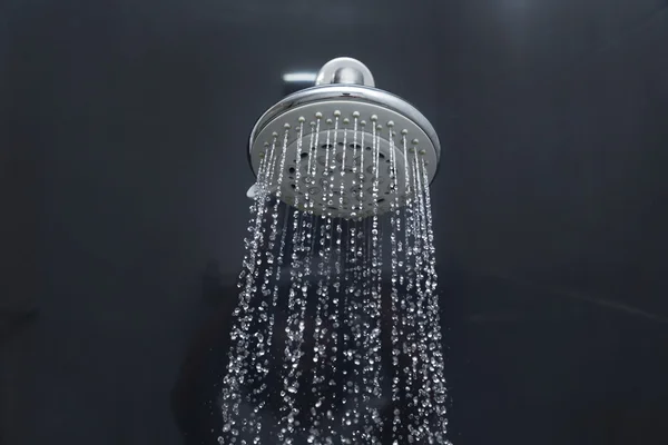 Duschkopf im Bad mit fließenden Wassertropfen — Stockfoto