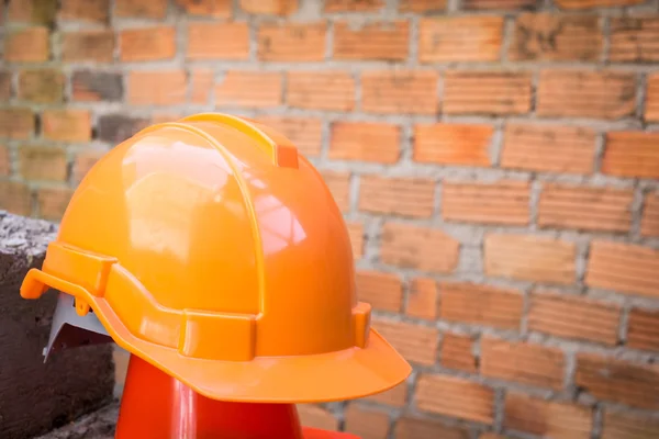 Casco de seguridad sombrero duro en el sitio de construcción con pared de ladrillo —  Fotos de Stock