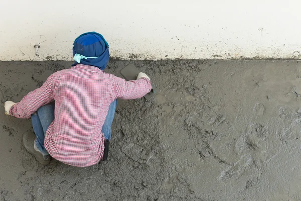 Plasterer concrete cement worker plastering flooring of house co — Stock Photo, Image