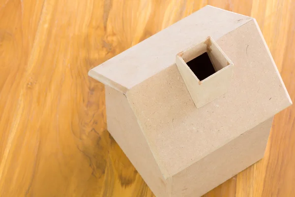 Modelo de casa de madera pequeña sobre fondo de madera marrón — Foto de Stock