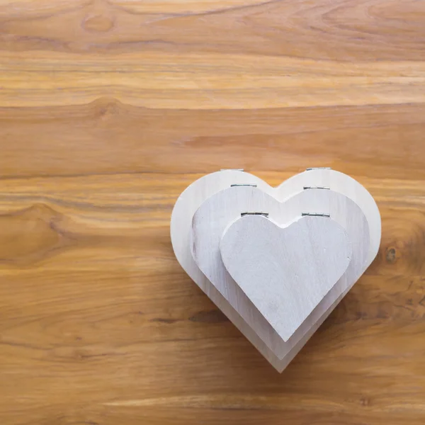 Caja de madera en forma de corazón sobre fondo de madera marrón —  Fotos de Stock