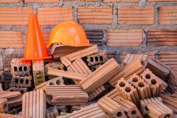 Casco de seguridad de sombrero duro y cono en el sitio de construcción —  Fotos de Stock