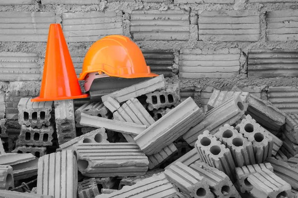 Casco de seguridad de sombrero duro y cono en el sitio de construcción —  Fotos de Stock