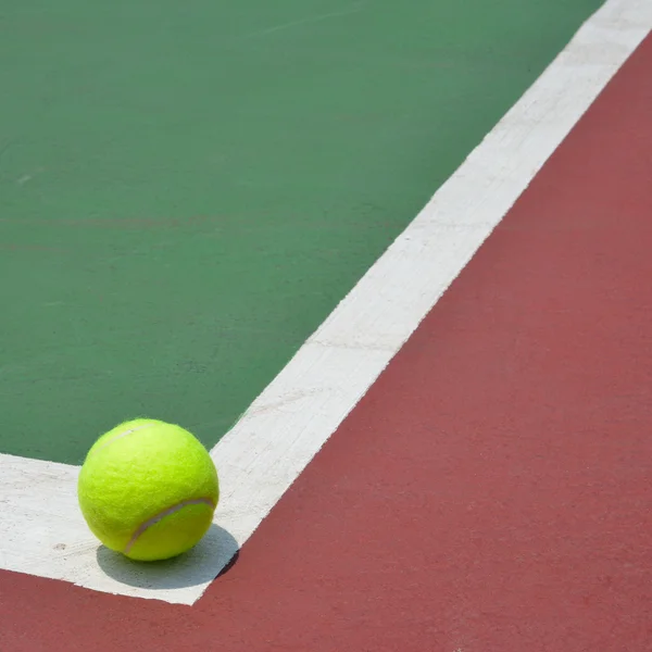Теннисный мяч на зеленой площадке — стоковое фото