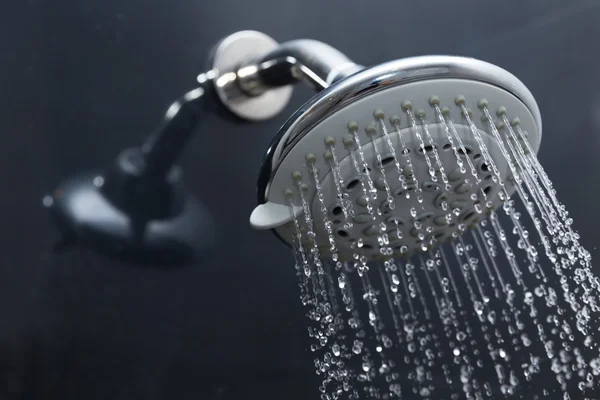 Duschkopf im Bad mit fließenden Wassertropfen — Stockfoto