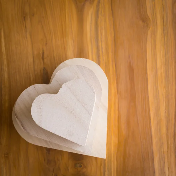 Dřevěné krabice ve tvaru srdce na hnědé dřevěné pozadí — Stock fotografie
