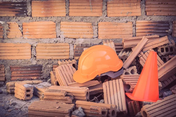 Casco de construcción de seguridad y cono en el sitio de construcción —  Fotos de Stock