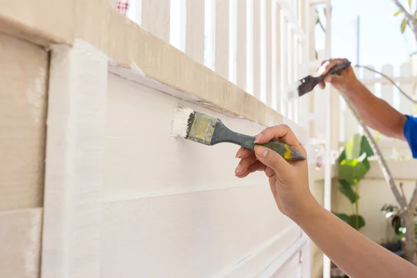 Hand werknemer houden borstel schilderij wit op houten hek — Stockfoto