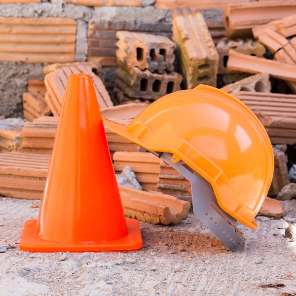 Casco de construcción de seguridad y cono en el sitio de construcción — Foto de Stock