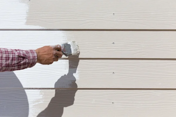 Hand worker holding brush painting white on wood fence — Stock Photo, Image