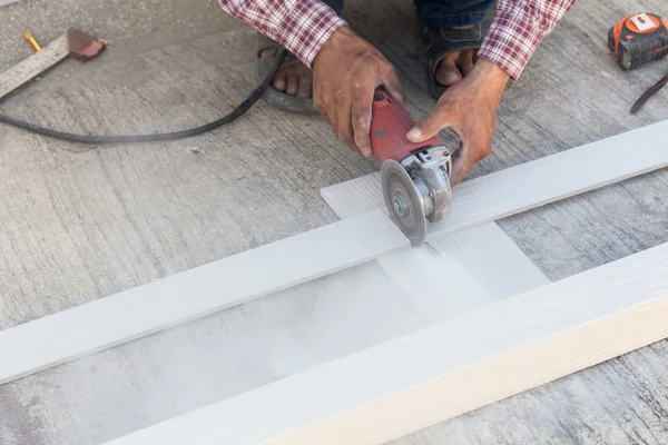 Timmerman handen met behulp van elektrische zag op hout op de bouwplaats — Stockfoto