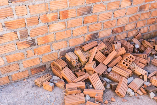 Stapel stenen in bouwplaats met bakstenen muur achtergrond — Stockfoto