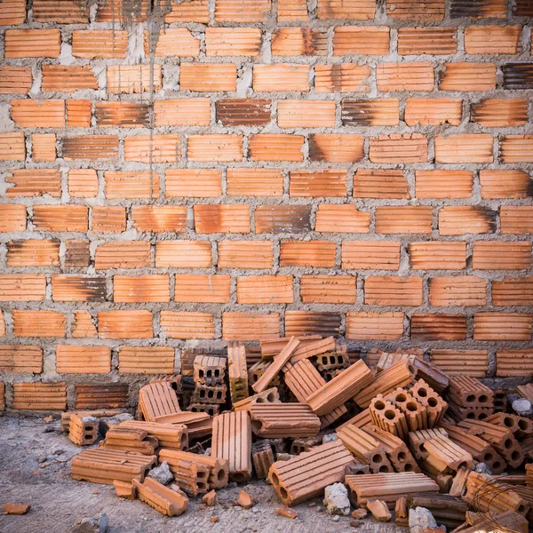Mucchio di mattoni in cantiere con sfondo muro di mattoni — Foto Stock