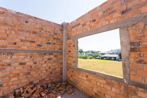 Pile de briques sur le chantier de construction avec fond de mur de briques — Photo