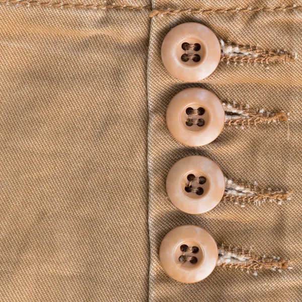 Design botton of brown shirt on fabric textile background — Stock Photo, Image