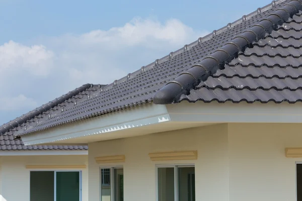 Tuiles de toit noir sur la maison avec ciel bleu — Photo