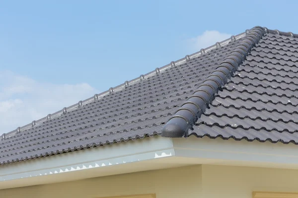 Tuiles de toit noir sur la maison avec ciel bleu — Photo