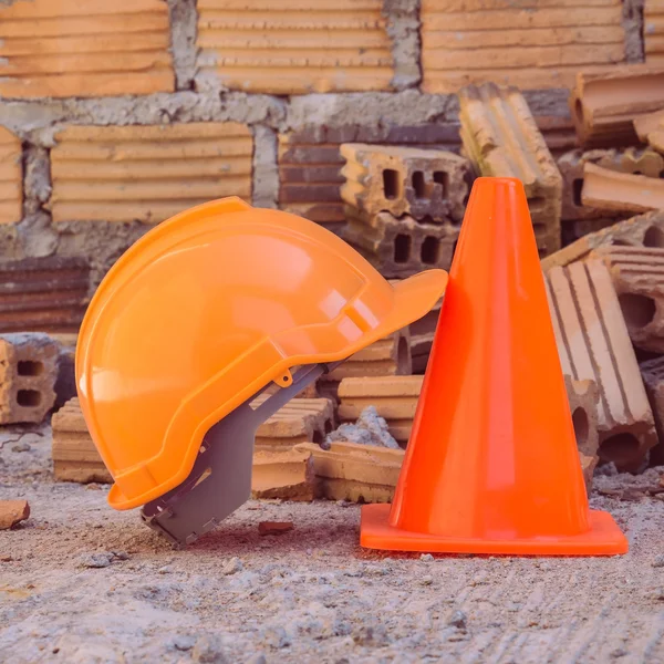 Casco de construcción de seguridad y cono en el sitio de construcción —  Fotos de Stock