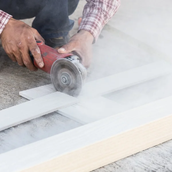 Tischler greift auf Baustelle mit Elektrosäge auf Holz — Stockfoto