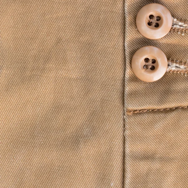 Design botton of brown shirt on fabric textile background — Stock Photo, Image