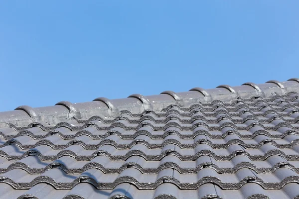 Tuiles de toit noir sur la maison avec ciel bleu — Photo