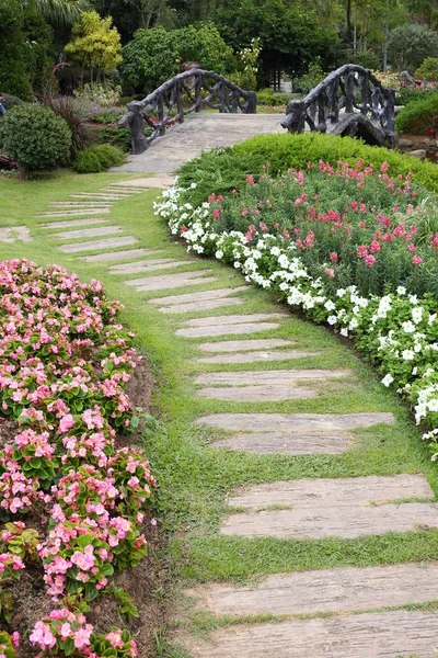 Landscape of floral gardening with pathway and bridge in garden — Stock Photo, Image