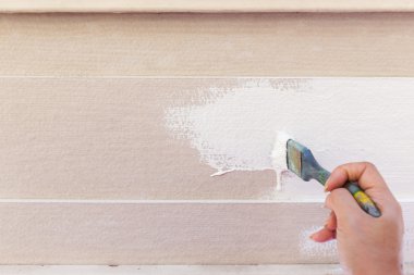 Fırça boyama ahşap çit üzerinde beyaz holding işçi el