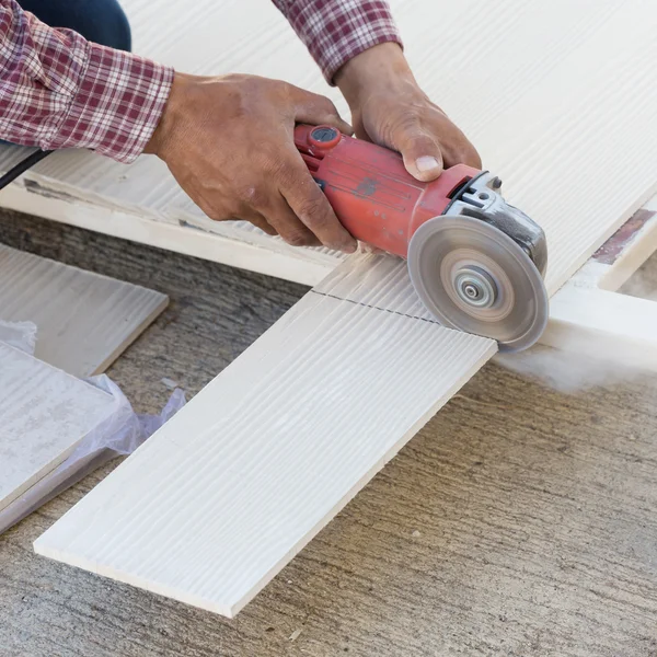 Mãos de carpinteiro usando serra elétrica em madeira no local de construção — Fotografia de Stock
