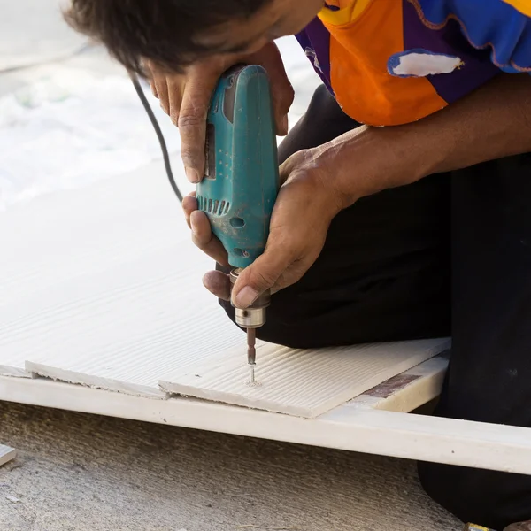 Timmerman handen met behulp van elektrische boor op hout tijdens bouw sit — Stockfoto