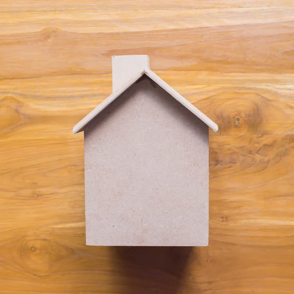 Liten trä hus modell på brunt trä bakgrund — Stockfoto