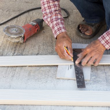 marangoz ahşap bir gemide işaretleme bir çizgi çizmek için cetvel kullanarak