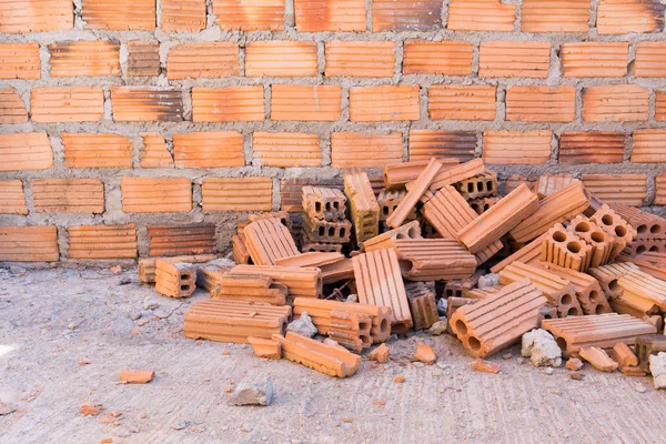 Stapel stenen in bouwplaats met bakstenen muur achtergrond — Stockfoto